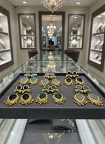 Collection of earrings with gemstone like stones on a white fur background