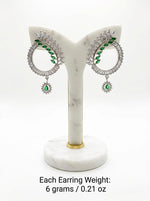 Contemporary green and white crystal statement earrings with a unique open-circle design and polished silver finish.
