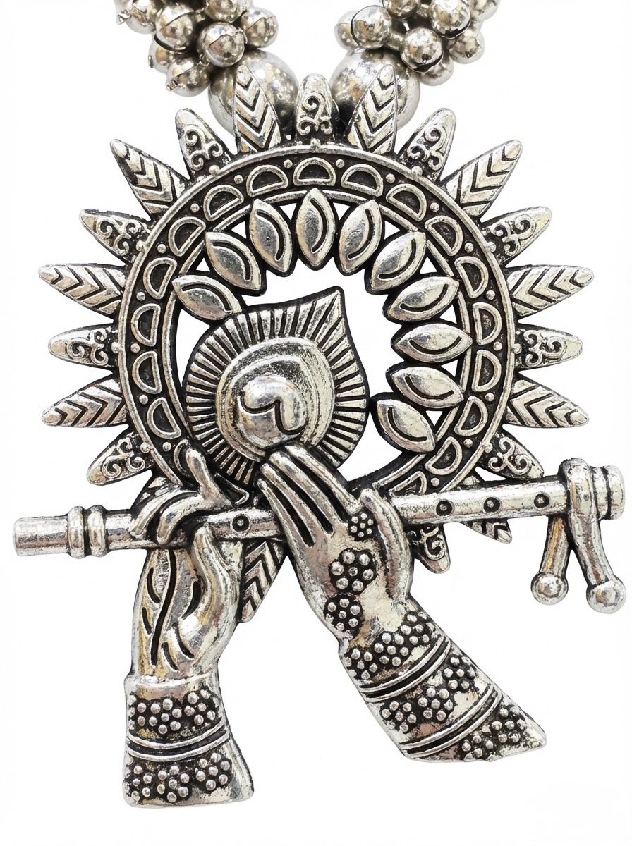 Decorative silver pendant with intricate designs on a white background