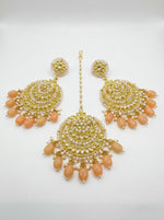 Detailed view of circular rose gold-toned statement earrings featuring peach accents and traditional kundan stonework.