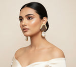 A pair of blue sugar stone stud earrings with gold-colored accents, displayed on a black stand.