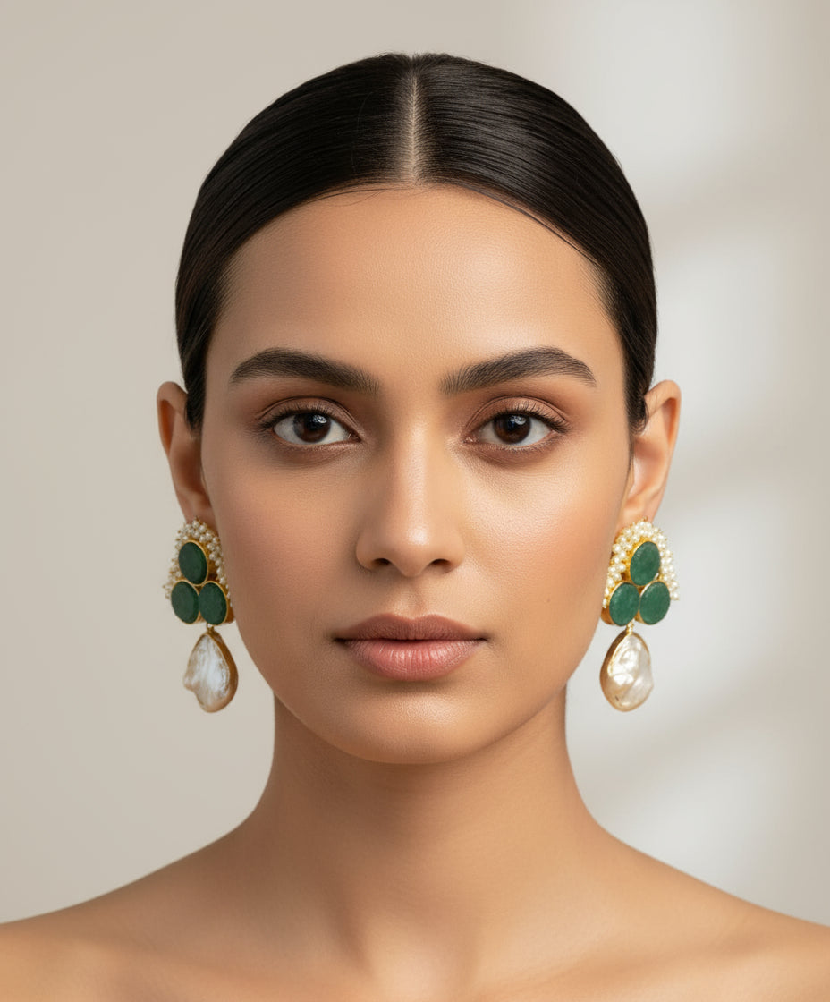 A pair of blue sugar stone stud earrings with gold-coloured accents, displayed on a black stand.