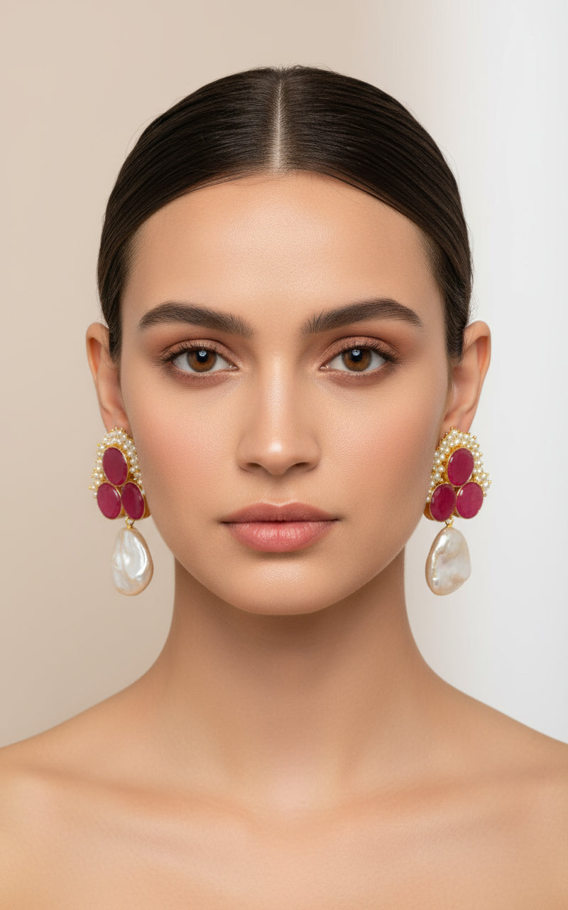 A pair of blue sugar stone stud earrings with gold-colored accents, displayed on a black stand.