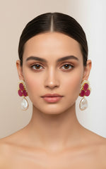 A pair of blue sugar stone stud earrings with gold-colored accents, displayed on a black stand.