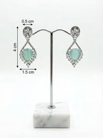 Earrings on a stand with measurements on a white background