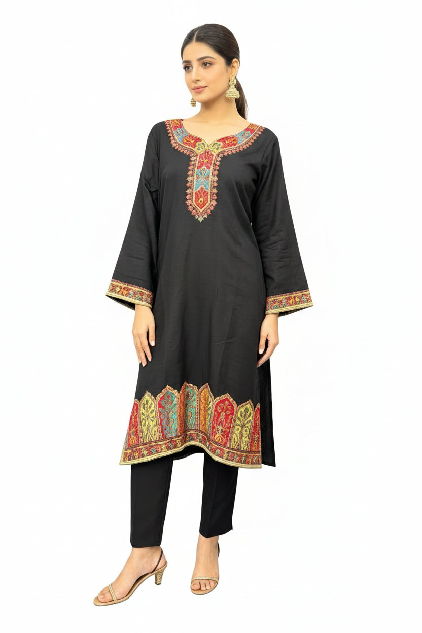 Model wearing a black silk kurta set with intricate Kanni embroidery and zari work, paired with a matching Banarasi chiffon dupatta and raw silk trousers, set against a pure white background.