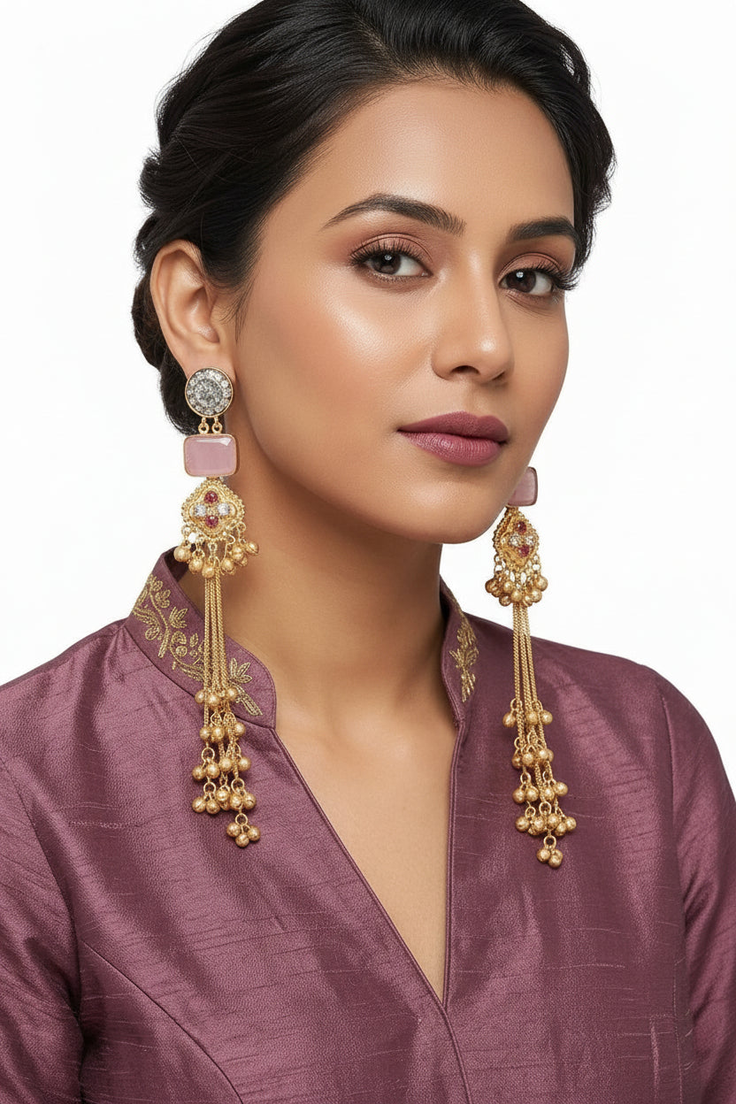 Elegant gold-toned laurel leaf earrings featuring a soft pink-colored cushion-cut stone drop worn by our model.