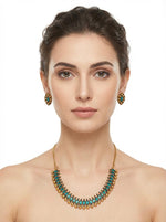 Elegant side-profile shot of a girl wearing the green stone gold-plated necklace and matching studs, showcasing the set's brilliant shine and festive appeal.