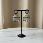 Elegant silver-plated Indian jhumke with striking black crystal accents arranged in a floral stud and dome pattern.
