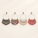 Four silver-tone Chandbali hoop earrings in black, multicolour, white and red on a pearl-white background.