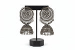 Front view of antique black jhumke on a luxury jewellery stand, highlighting the intricate craftsmanship of these posh evening jewellery pieces.