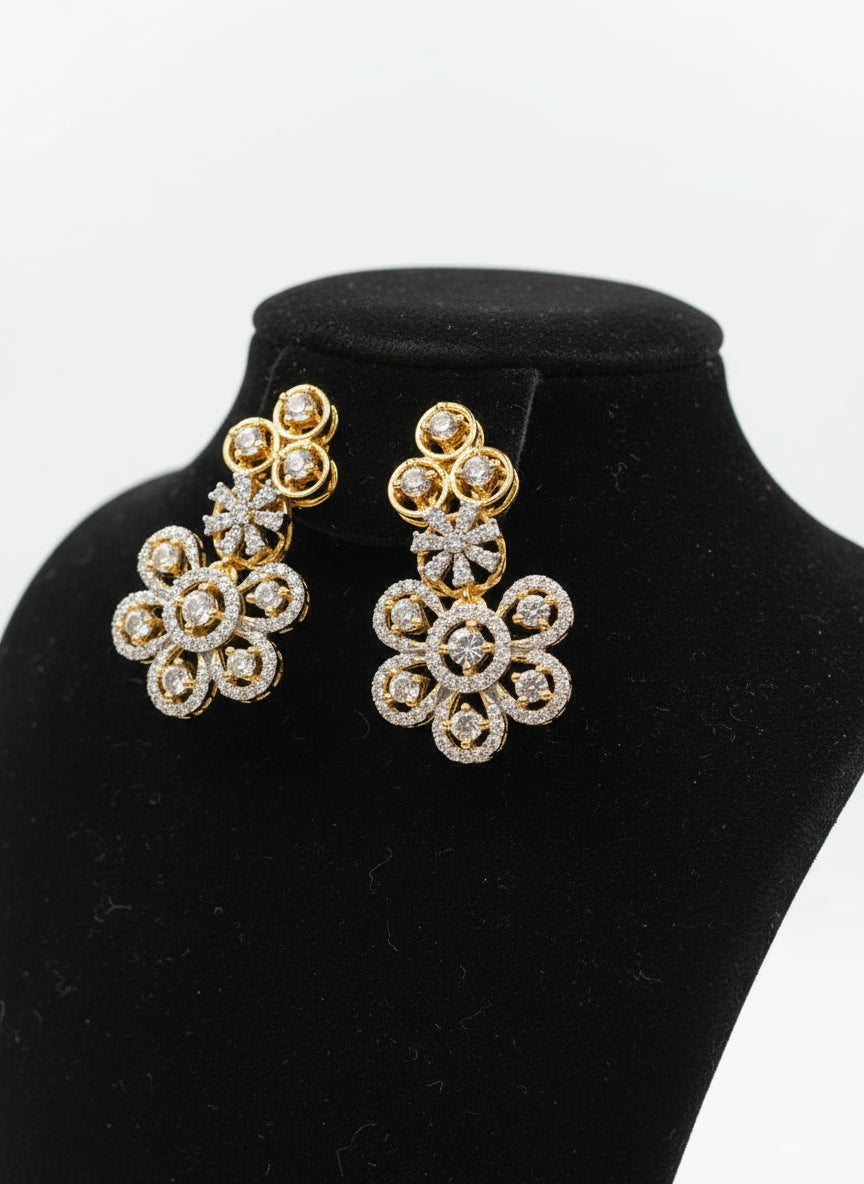 Gold and diamond earrings on a white stand