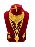 An ornate gold jewelry set displayed on a red velvet mannequin bust, including a heavy choker necklace, a long pendant necklace, a matching necklace with a decorative clasp, and two matching earrings.