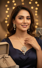 Gold plated a set of peacock-shaped pendant in golden chain with peacock-shaped earrings. The pendant is detailed with blue enamel and has sparkling crystal white AD stones embellishments. Party wear jewellery set.