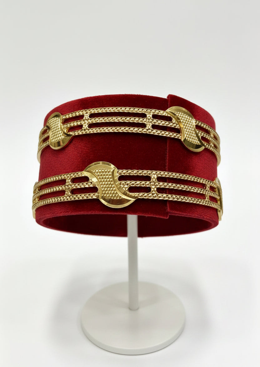 Gold bracelet on a white stand against a white background
