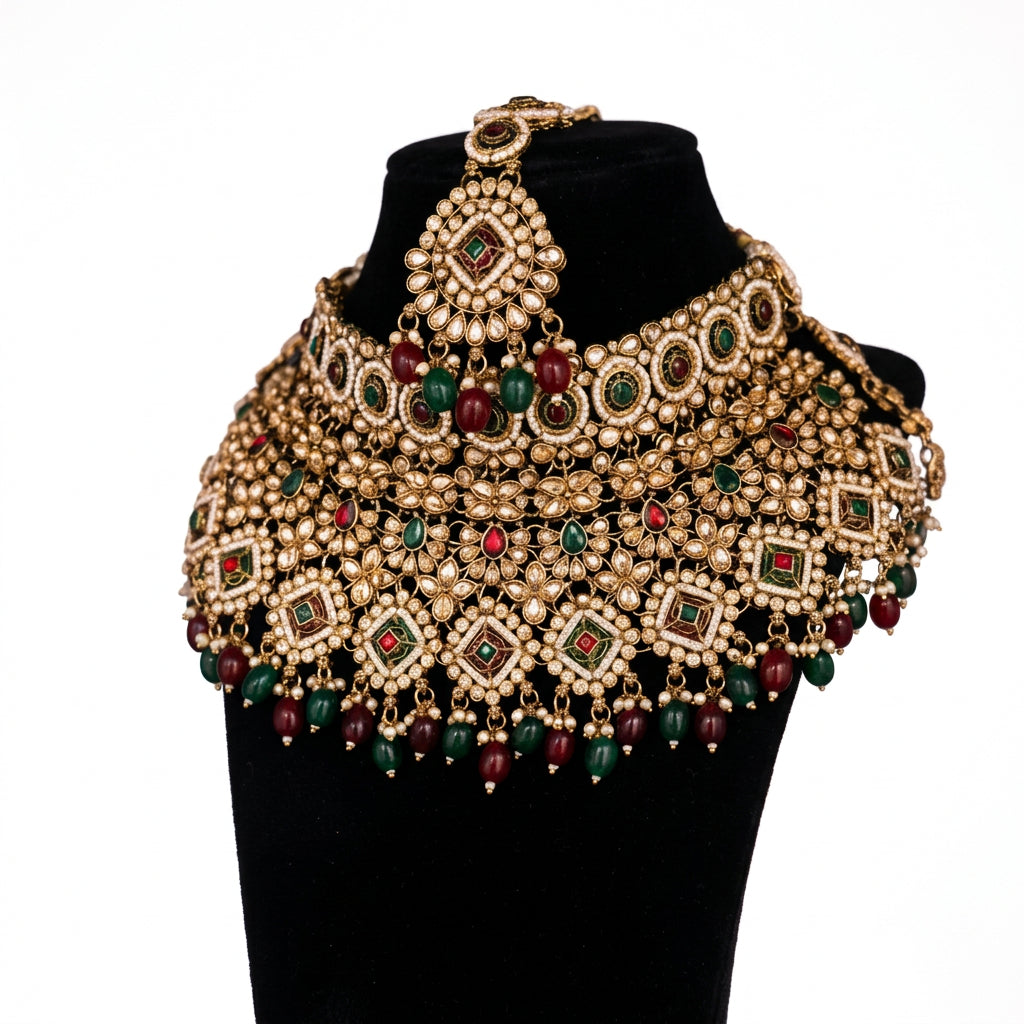 Grand golden bridal choker necklace with multicolor stonework and red and green bead droplets.