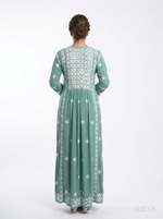 Green embroidered dress worn by a person on a white background