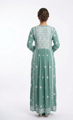 Green embroidered dress worn by a person on a white background