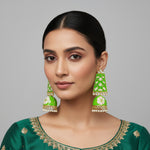 A pair of gold-plated Meenakari long Jhumka earrings with green and white enamel work and pearl accents.