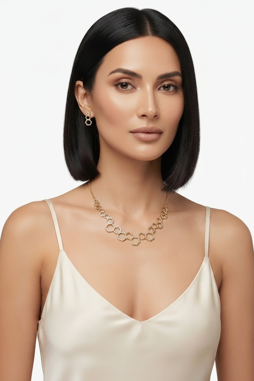 A model wearing an exquisite 18k gold plated geometric necklace featuring a honeycomb-inspired pattern with matching earrings, highlighting elite craftsmanship and unparalleled refinement.