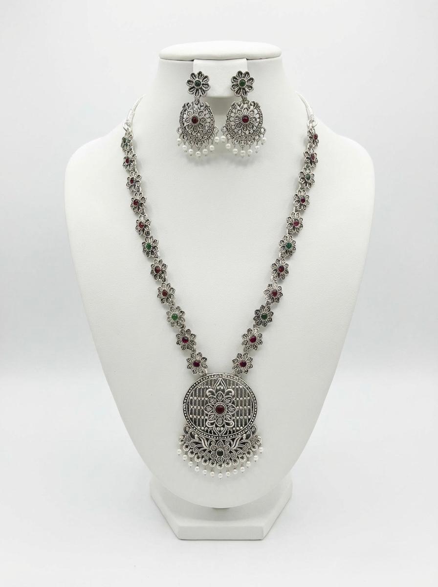 High-grade silver oxidised medallion necklace set with matching earrings on a display stand, showcasing the premium alloy craftsmanship and antique polish.