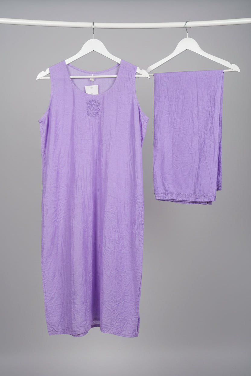 A lavender purple chanderi fabric sleeveless embroidered kurta hanging on a white hanger with matching straight trousers displayed for Famaza Couture