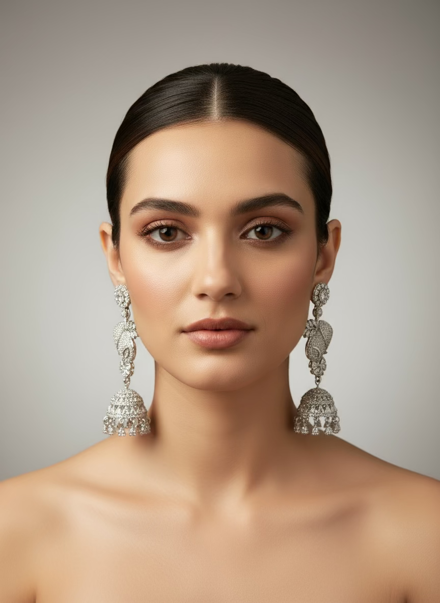 A pair of silver finish American diamond drop Jhumka earrings displayed on a stand.