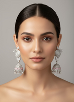 A pair of silver finish American diamond drop Jhumka earrings displayed on a stand.