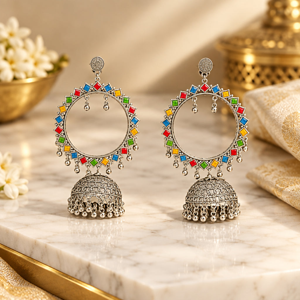 A pair of silver-toned Indian hoop jhumka earrings with vibrant multicolour enamel detailing in red, blue, green, and yellow, displayed on a black jewellery stand. The drop length from top to bottom is 14cms and hoop width is 7cms and bottom dome width is 4cms.