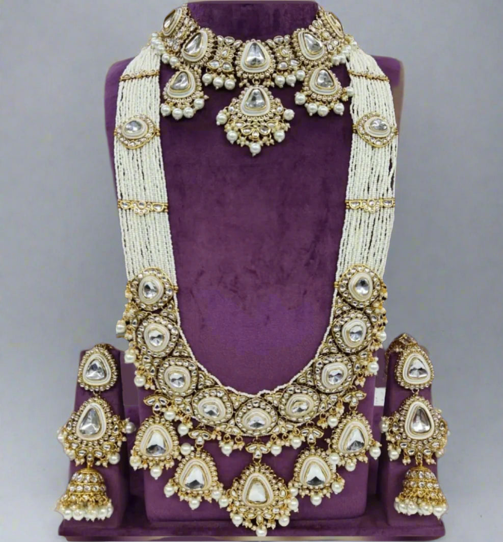 10-piece Kundan bridal jewellery set with pearl layers and emerald green beads – necklace, earrings, and accessories on display