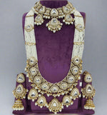 10-piece Kundan bridal jewellery set with pearl layers and emerald green beads – necklace, earrings, and accessories on display