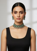 Jewellery set with emerald green stones on a black stand