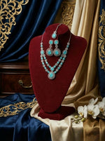 Jewellery set with turquoise stones on a red velvet stand against decorative fabric background