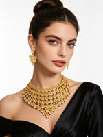 A model wearing the Laiba gold-plated floral statement collar necklace and matching filigree earrings from Famaza Couture.