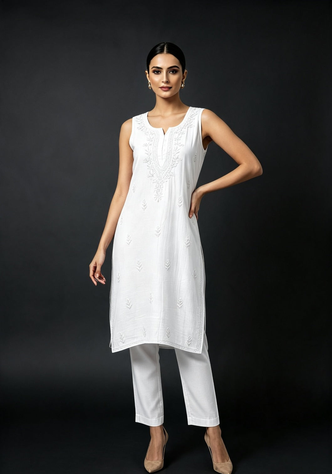 A model wearing the white handcrafted sleeveless Chanderi silk Chikankari co-ord set, posing against a solid dark background.