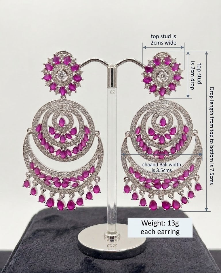A pair of Luxe Fuchsia Crescent Chandbali Statement Dangle Earrings displayed on a stand, showcasing detailed dimension measurements and vibrant pink stone craftsmanship.