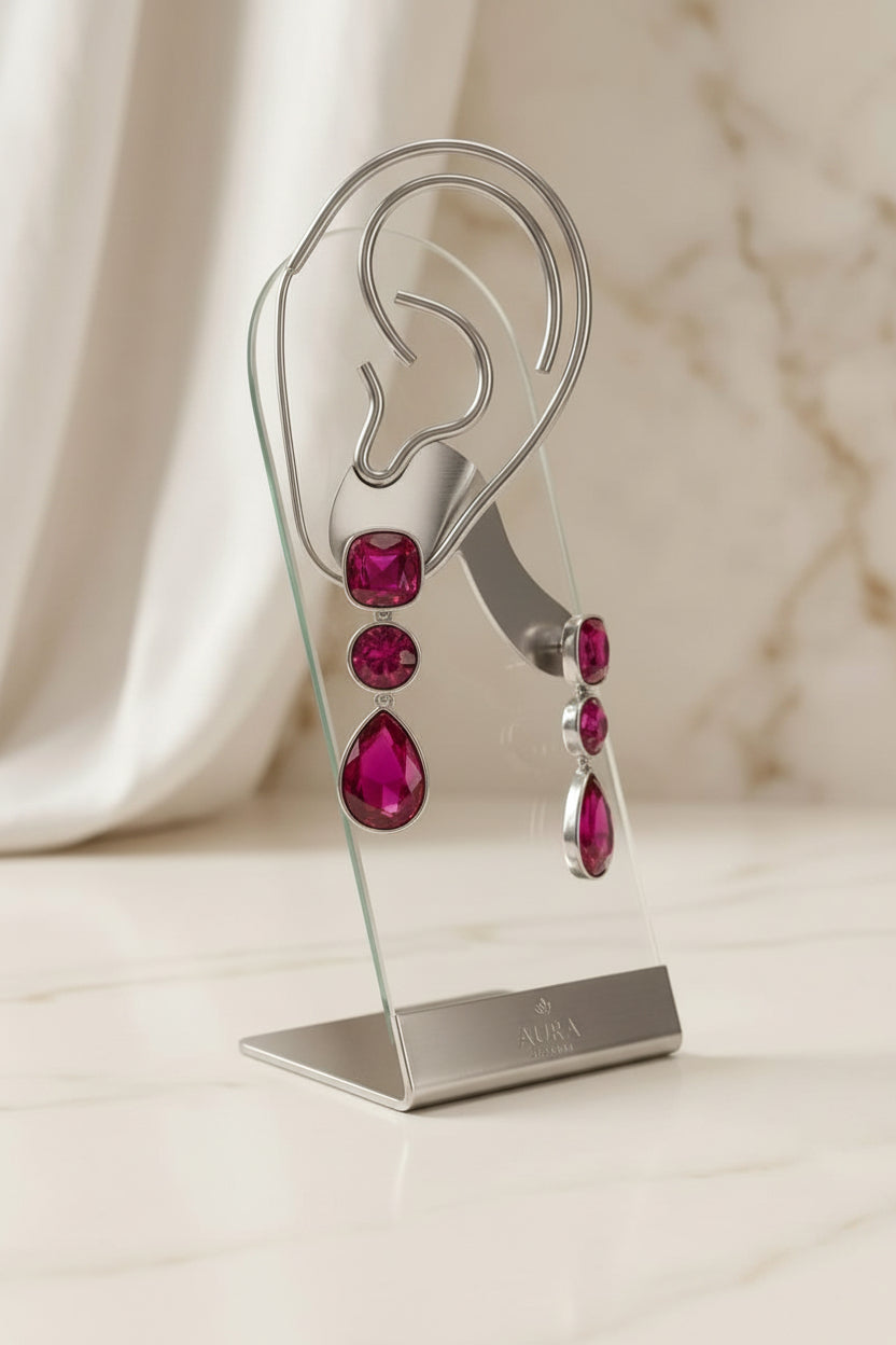 Deep pink tiered crystal earrings on a rose gold ear display stand.