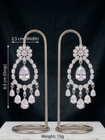 A pair of silver-tone drop chandelier earrings with clear teardrop and floral crystals, displayed on a white marble block against a black background. White text overlays show dimensions (2.