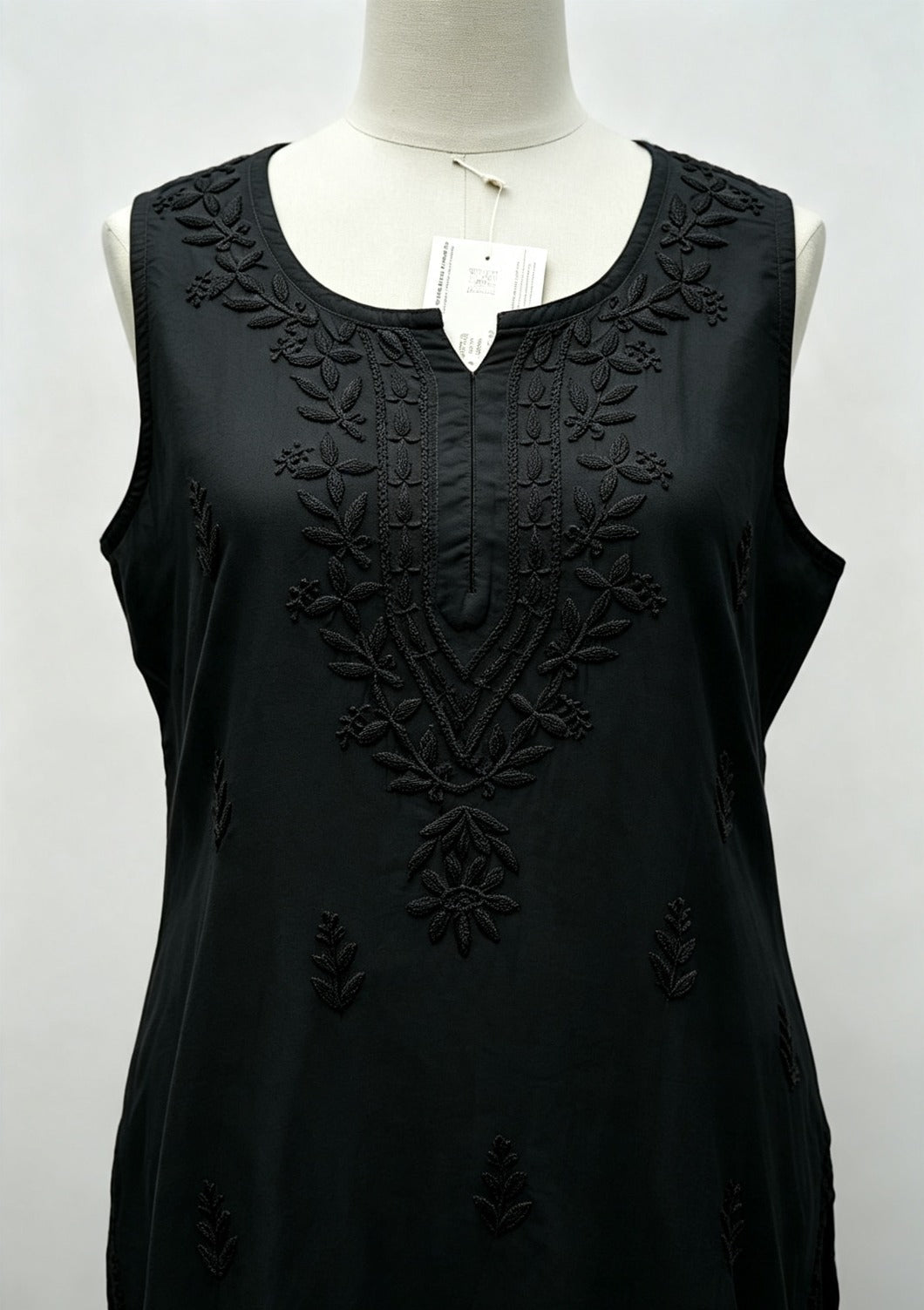 Close-up front view of a black handcrafted sleeveless Chanderi silk Chikankari co-ord set displayed on a mannequin, highlighting the detailed tonal embroidery around the neckline and front panel.