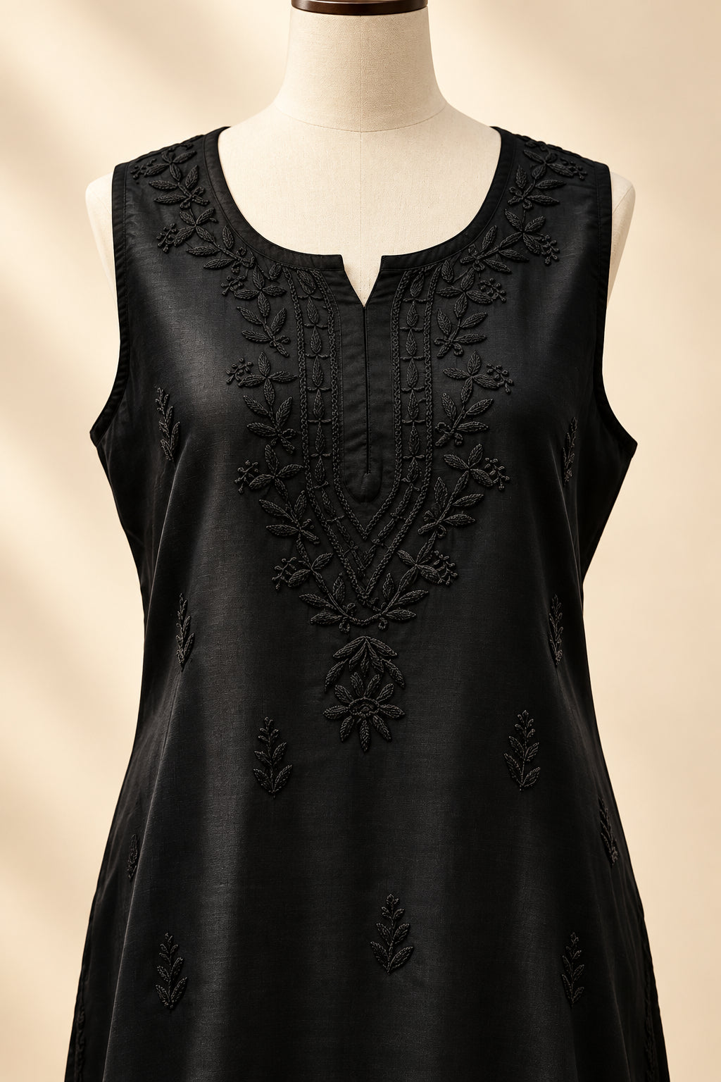 Close-up front view of a black handcrafted sleeveless Chanderi silk Chikankari co-ord set displayed on a mannequin, highlighting the detailed tonal embroidery around the neckline and front panel.