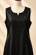 Close-up front view of a black handcrafted sleeveless Chanderi silk Chikankari co-ord set displayed on a mannequin, highlighting the detailed tonal embroidery around the neckline and front panel.