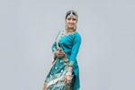 Model in traditional green bridal gharara outfit with floral patterns