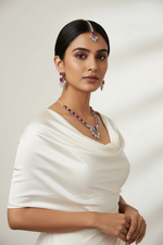 Model is wearing The American diamond jewellery set including necklace, earrings and maang tikka with ruby centre stone.