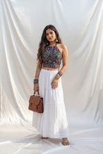 Model is wearing the white rayon skirt with white Ghasspati hand embroidery on the bottom two layers and the hem is adorned with white crochet lace.