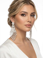 Model wearing Sophisticated silver-toned tiered earrings with a delicate fringe of white pearl beads for festive occasions.