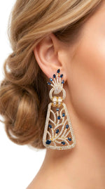 Model wearing elegant silver-toned dangle earrings with royal blue stones and intricate American Diamond filigree detailing.