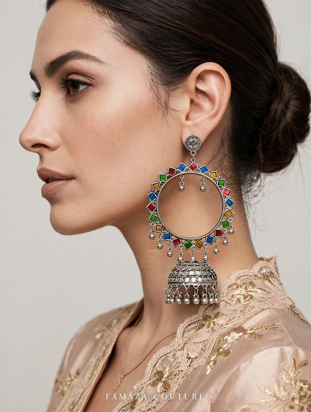 Model wearing multicolour enamel-painted silver-tone hoop jhumka earrings.