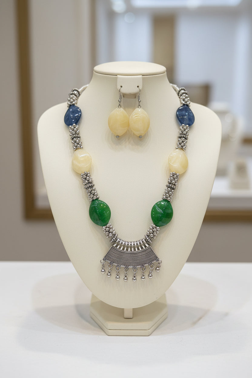 Necklace with green and blue stones on a black stand