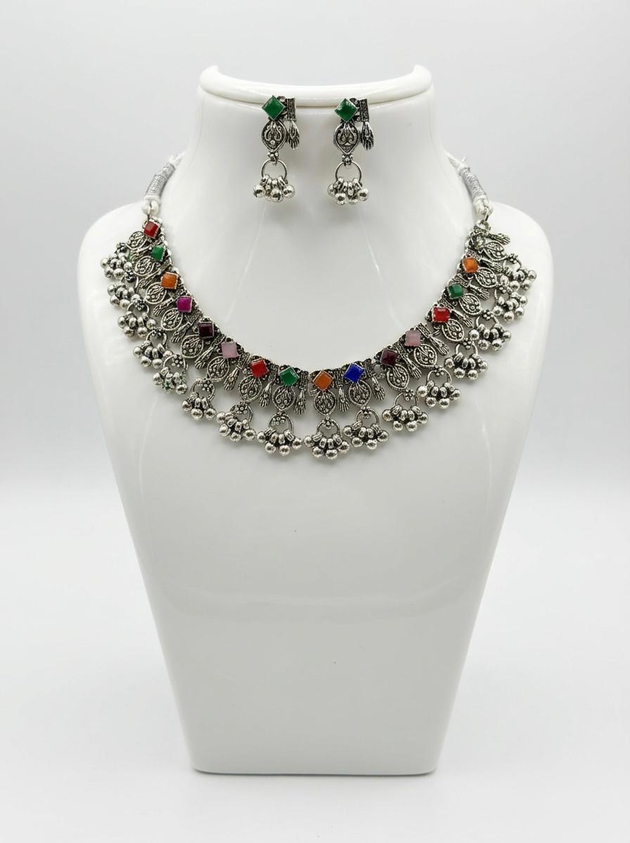 Premium silver oxidised multicolour floral choker set on a display stand, highlighting the green stone accents and high-grade artisanal craftsmanship.