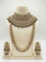 Ornate Bridal Jewellery set including necklace set with green and red stones on a mannequin bust against a white background
